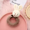 Cute plush animal hair tie detail, fluffy brown hair ring with sweet bow decoration closeup. - White Bowknot Bunny + Coffee Hair Tie
