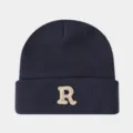 Gros plan détaillé du bonnet en tricot bleu marine avec un élégant motif de lettre R brodé. - Gris foncé