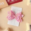 Détail en gros plan de la pince à cheveux nœud pailleté rose sur carte blanche. - Style Pince Bec de Canard / Rose rouge