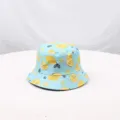 Vista cercana detallada del sombrero de cubo con estampado de limones para protección solar. - Azul cielo