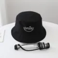Detalle del sombrero de pescador con visera protectora extraíble y bordado de sonrisa negra. - Adulto / Doble Cara Negro con Blanco y Protector Facial