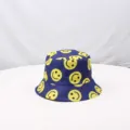 Detalle en primer plano del clásico sombrero de pescador azul con divertidas caras sonrientes. - Talla única / Azul zafiro