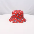 Primer plano detallado de un sombrero de pescador rojo con un estampado de ojos azules. - Rojo
