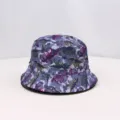 Detailed view of the stylish dinosaur printed bucket hat, showing the purple pattern fabric clearly. - One Size / Purple