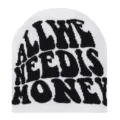 Detailed view of white knit beanie featuring bold black slogan text, cozy winter accessory. - White