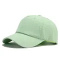 Close up detail of the light green cotton baseball cap showing curved brim and breathable eyelets. - Emerald Green