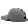Vista detallada de la ranura trasera para coleta y hebilla ajustable en la gorra lavada. - Gris claro