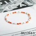 Minimalistisches orange-weisses Rocailles-Armband mit goldenen Metallperlen, zierlich. - Orange Weiß Mehrfarbiger Stil (BR2178-B-9)