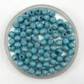 Detailed view of turquoise acrylic pumpkin beads with silver stripes for DIY jewelry making. - 8mm / Lake Blue