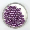 Close-up detail of purple ABS plastic faux pearl beads with pre-drilled holes for DIY jewelry. - Purple