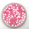 Close-up of pink and white heart-shaped acrylic beads, perfect for DIY jewelry making. - Pink