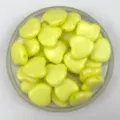 Close-up detail of yellow acrylic heart-shaped loose beads with horizontal holes for DIY jewelry. - Solid Yellow