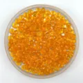Close-up of vibrant orange faceted acrylic crystal rondelle beads in a round transparent tray. - Orange Red