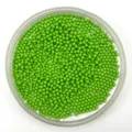 Close-up detail of vibrant green solid plastic micro beads arranged neatly in a clear round tray. - 2.0mm / Solid Green