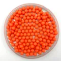 Closeup detail of vibrant orange solid round plastic beads displayed in tray for DIY crafts. - 6mm / Orange Red