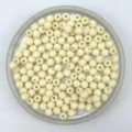 Close-up detail of matte acrylic round seed beads in a tray, perfect for DIY jewelry making. - 6mm / Off White