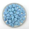 Close-up detail of light blue matte heart beads, perfect for DIY bracelets and jewelry making. - 12mm / Light Blue