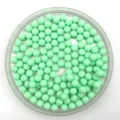 Close up product detail of light green solid round acrylic beads neatly displayed in tray. - 6mm / Emerald Green