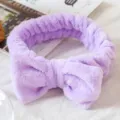 Vue détaillée du bandeau nœud en peluche violette douce, texture polaire corail moelleuse. - Violet