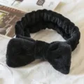 Close-up of black plush bow headband, soft texture design for daily makeup and skincare. - Black