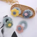 Gros plan d'élastiques à cheveux pelucheux à fleurs, texture douce et colorée pour style mignon. - Bande Bleue + Fleur Jaune