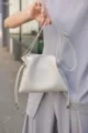 Nahaufnahme des weichen Leder-Kordelzug-Tasche in Hellgrau, feine Textur zeigend. - Milchweiß