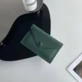 Détail d'étui de carte enveloppe en cuir vert foncé, mini portefeuille souple à bouton-pression. - Vert