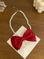 Detail shot of the French style red bow faux pearl necklace, showing delicate bow and pearls. - Bowknot Pearl Necklace(GC1544) / Red