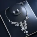 Close-up detail of silver floral pearl rhinestone necklace and matching earrings set. - Silver