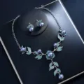 Detail shot of a stunning jewelry set featuring silver tone, dark pearls, and blue crystal leaves. - Lake Blue Pearl Set