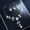 Detailed view of the elegant pearl and rhinestone necklace and earrings set, sparkling floral design. - Silver Pearl Set