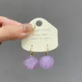 Close-up detail view of elegant purple round ball earrings with copper hardware components. - Lavender