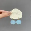 Detailed close-up of light blue round drop earrings with golden hooks, sweet and stylish. - Light Blue