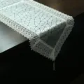 Detailed view of modern geometric PU leather table runner with white lace edges for home decor. - 40*150 cm / Style One Silver White
