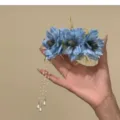 Blue artificial flower hair clip with elegant pearl tassel drapes, delicate detail view. - Blue