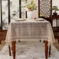Close-up view of intricate floral lace embroidery on an elegant beige table cloth detail. - 100×150 cm / Coffee