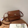 Retro brown genuine leather shoulder bag detail showing fine stitching and metal buckle clasp. - Dark Brown