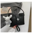 Sac seau noir en cuir texturé avec fermoir chic et charm en peluche adorable. - Noir Avec Pendentif