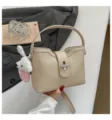 Sac seau chic texture litchi avec charm en peluche mignon pour navettage elegant. - Khaki Avec Charme