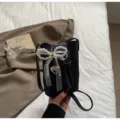 Mini black bucket bag for women, cute pearl bow and heart charm, stylish crossbody phone bag. - Pearl Pendant / Black