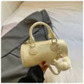 Chic beige cylinder pillow shoulder bag for women, stylish crossbody bag with cute plush charm. - With Pendant / Yellow