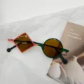 Vista detallada de gafas de sol asimétricas de tendencia para niños con estilo moderno. - Naranja Verde Lente Marrón