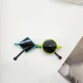 Primer plano de gafas de sol para niños asimétricas con montura geométrica moderna. - Verde Amarillo Lente Gris
