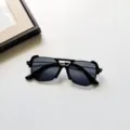 Gros plan sur des lunettes de soleil pour enfants noires au cadre carré et design unique. - Noir