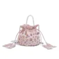 Vista detallada del elegante bolso saco de color rosa con cristales y asa de perlas. - Rosa