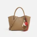 Khaki pebble leather crossbody handbag with baseball charm and stylish shoulder strap for women - Amber