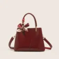 Bolso de mano rojo estructurado con solapa asimétrica y elegante bufanda estampada. - Cuero encerado rojo vino