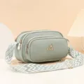 Bolso cruzado de cuero verde con correa tejida ancha, diseño de múltiples compartimentos. - Verde claro