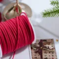 Primo piano del cordoncino in finta pelle scamosciata rossa su roccolo con decorazioni natalizie. - Rosso 45m