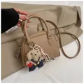 Chic pebbled leather dome handbag featuring a cute plush dog pendant and crossbody strap. - With Pendant / Khaki